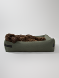 Afbeelding geladen in Galerij-viewer, Green eco-friendly dog bed from Hygge collection with a comfortable design featuring a brown dog lying down.