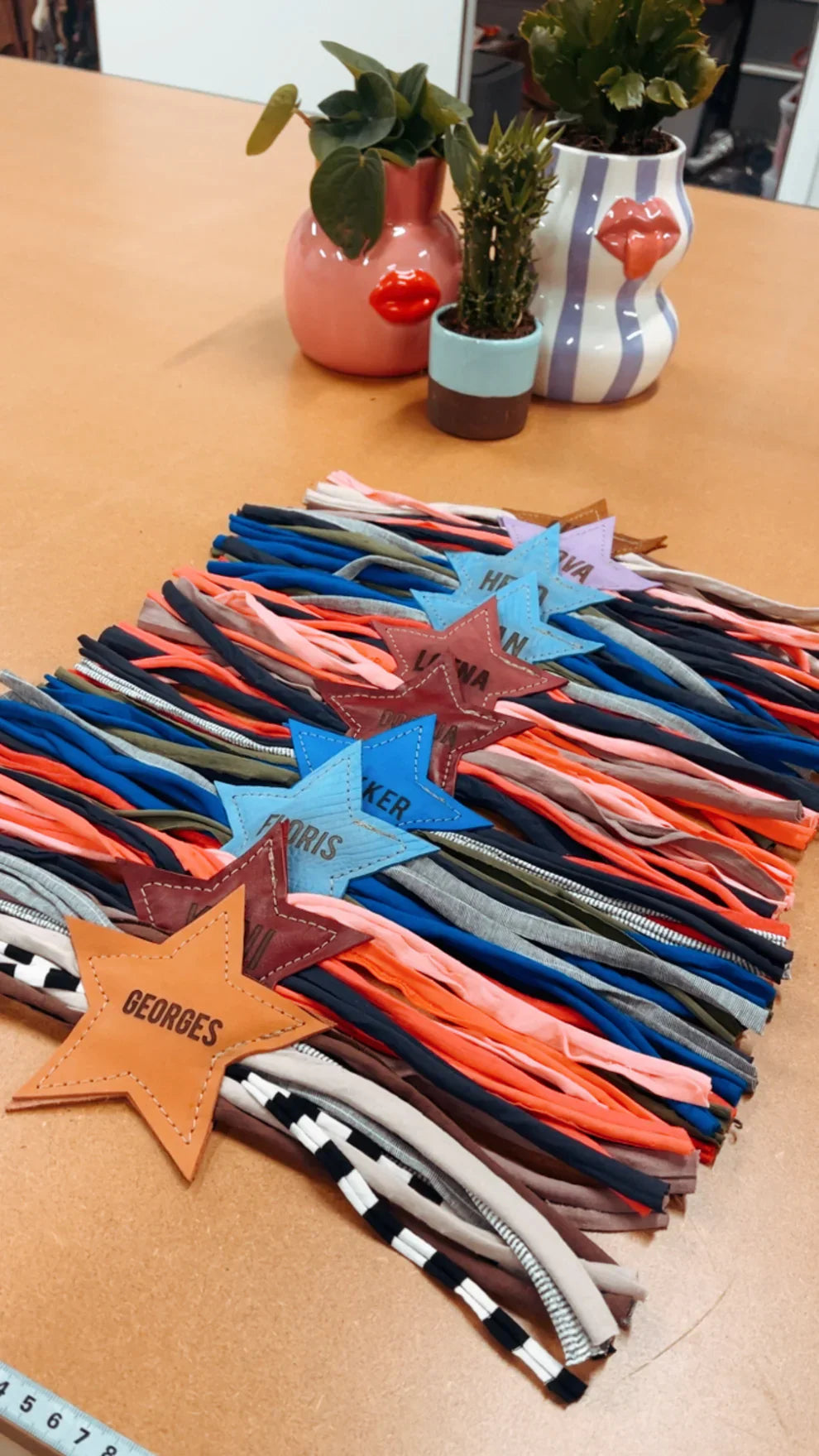 Personalized leather star dog toys with colorful fabric tails on a table